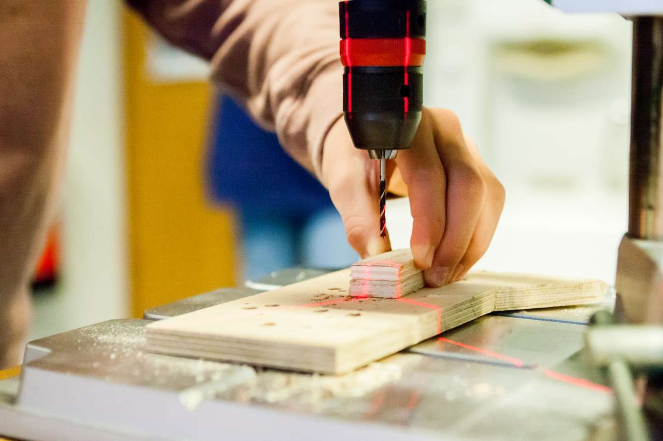 Schüler bohrt in ein Stück Holz