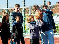 Ältere Schüler zeigen jüngeren Balltricks