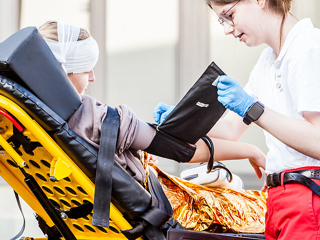 Schulsanitäterin verarztet Schülerin