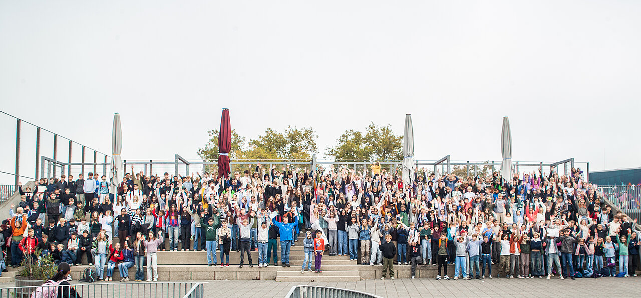 Gruppenfoto mit vielen Schülerinnen und Schülern auf dem Schulhofgelände